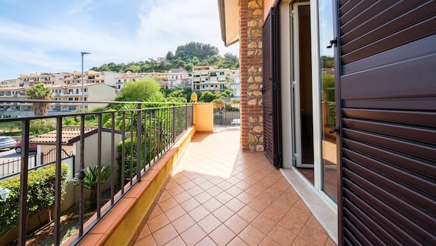 Een balkon met uitzicht op omliggende gebouwen en een heldere lucht.