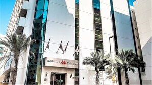 A modern building with a prominent 'Golden Sands' sign, large windows, and a clear blue sky. - Golden Sands 5 Hotel Apartment (Dubai)