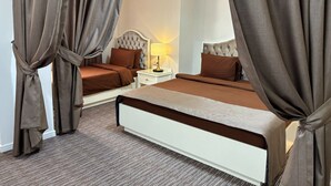 Una cama doble con cabecera, una mesita de noche con lámpara y cortinas.