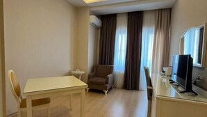 Una sala de estar moderna con una mesa de comedor, un sofá, un televisor y una lámpara de techo.