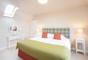 A bedroom with a bed, two bedside tables, a nightstand, a window, and a headboard. - Holstein Cottage - The Dairy at Daviot (Daviot)