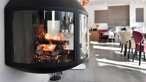 A modern interior with a glass-fronted fireplace, contemporary furniture, and a neutral color palette. - Zenao Appart'hôtels Massy (Massy)