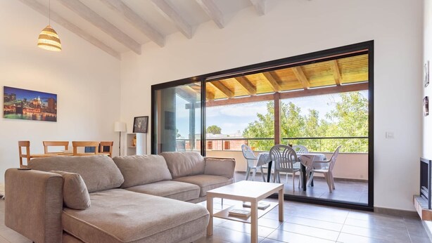 A living room with a sofa, a coffee table, and a balcony with a table and chairs. - Apartment Gran Terraza Exclusive Costa Dorada (Bonmont Terres Noves)