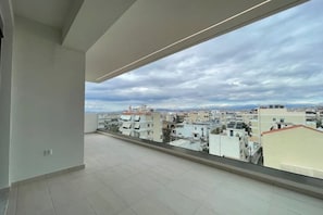 Eine hohe Wohnung mit einem großen Fenster und Blick auf eine Stadtlandschaft.
