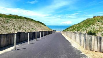 A coastal road with wooden barriers and a clear view of the ocean.
