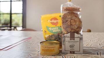 Una mesa con una lata de paté campestre, una bolsa de Pedigree Tasty Minis y un paquete de croquants.