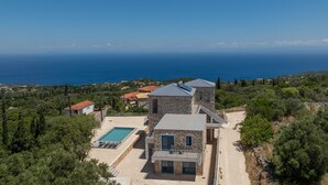 Ein Steinhaus mit Pool, Balkon und Meerblick.