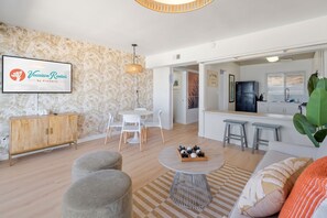 A modern living room with a dining area, a kitchen, and a large window. - Sea Cliff #8 | La Palma (San Diego)