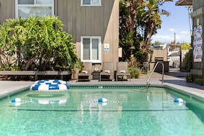 A clear swimming pool with lounge chairs and a no diving sign. - Seabreeze - Ocean Front (San Diego)