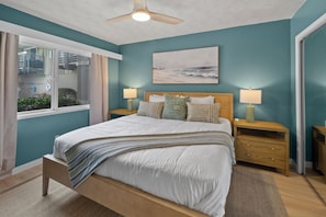 A bedroom with a bed, bedside tables, a ceiling fan, a window with curtains, and a painting on the wall. - Seabreeze - Ocean Front (San Diego)
