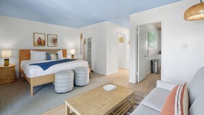 Ein modernes Hotelzimmer mit Bett, Holztisch, Sofa und Esstisch.