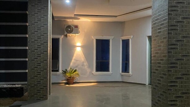 Een modern interieur met een centrale lamp, een potplant en een trap.