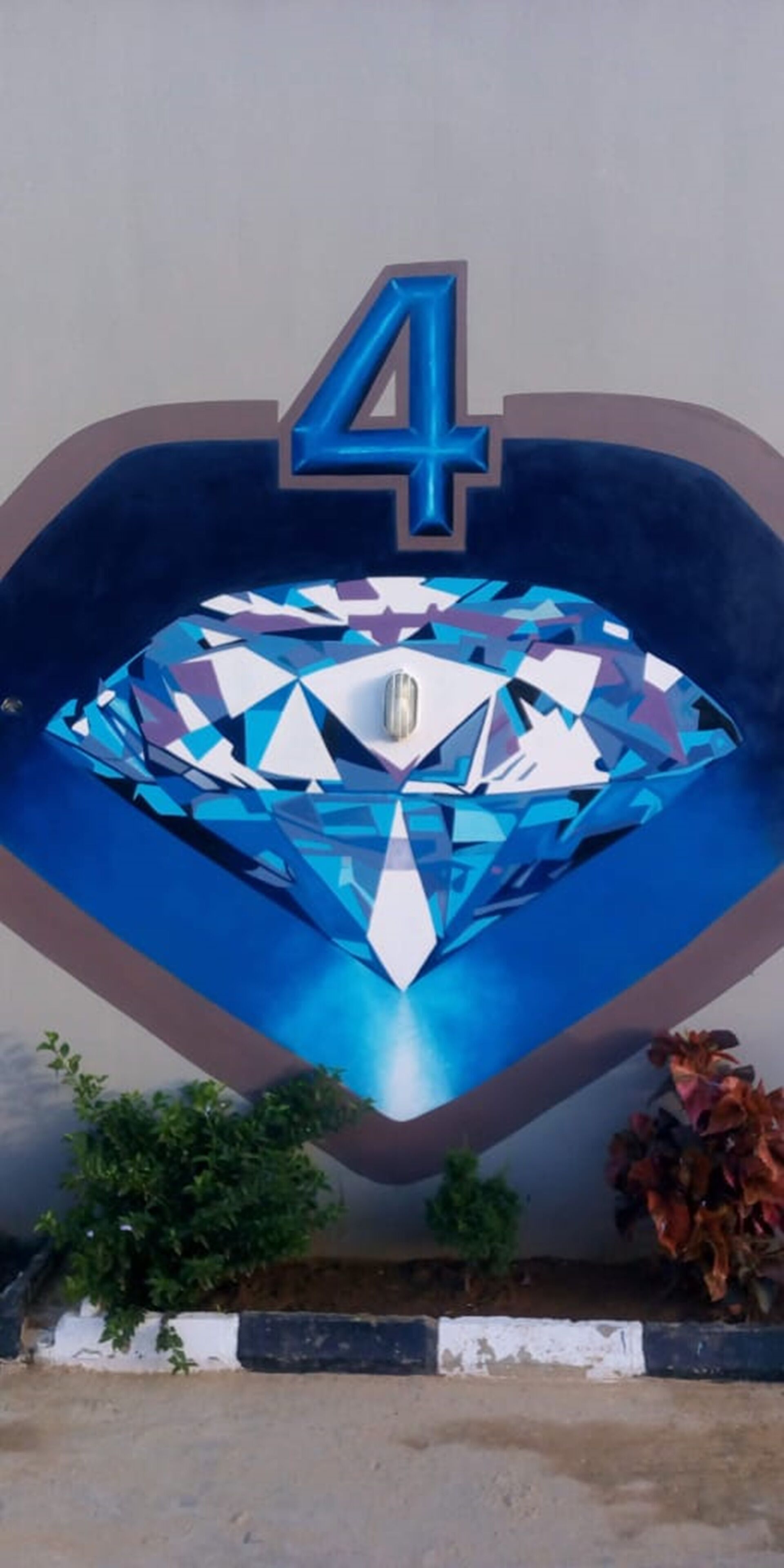 Eine herzförmige Wanddekoration mit einem großen blauen Diamanten und der Zahl 4.