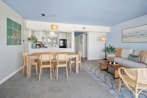 A modern living room with a dining area, a sofa, and a coffee table. - The Sandbar - Ocean Front (San Diego)