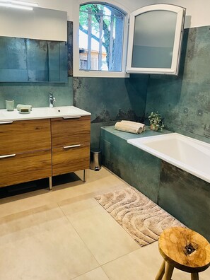 A modern bathroom with a wooden vanity, a white sink, a large mirror, and a bathtub. - Villa with all the amenities, ideal for families or friends: pool, PS5, paddle (Solliès-Pont)
