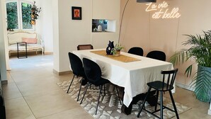 A dining area with a table, chairs, a chandelier, and a neon sign. - Villa with all comforts, ideal for families or friends: swimming pool, ps5, paddles (Solliès-Pont)