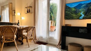 A hotel room with a dining area, a TV mounted on the wall, a large window with a view of a mountainous landscape, and a fireplace. - Villa with all comforts, ideal for families or friends: swimming pool, ps5, paddles (Solliès-Pont)