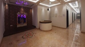 A hotel lobby with a reception desk, a decorative wall, and a chandelier. - HOTEL NEEL GAGAN  (Varanasi)