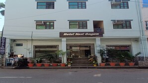 A hotel named 'Hotel Noel Gagan' with a flat facade, multiple windows, and a flag on top. - HOTEL NEEL GAGAN  (Varanasi)