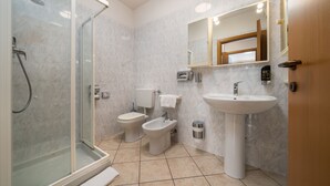 A modern bathroom with a glass shower enclosure, a toilet, a bidet, a sink, and a mirror. - HOTEL MAX  LAZISE (Lazise)