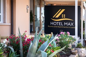 A hotel sign with a logo and text indicating it is Hotel Max, offering rooms and apartments in Las Vegas. - HOTEL MAX  LAZISE (Lazise)