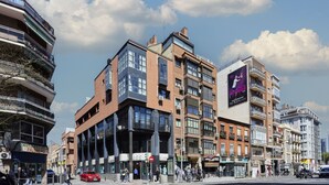 A multi-story building with a mix of commercial and residential spaces, including a visible storefront and balconies. - Santa Rosa Madrid 204 by Escape Home (Madrid)