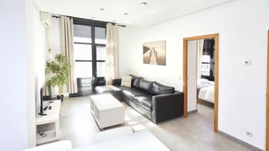 A modern living room with a sofa, a coffee table, a TV, and a plant. - Santa Rosa Madrid 204 by Escape Home (Madrid)
