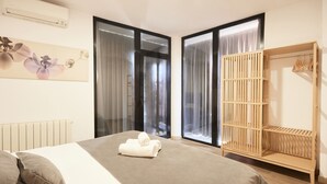 Ein Schlafzimmer mit einem Bett, einem Holzschrank und einem Fenster mit Vorhängen.