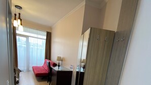 A hotel room with a bed, a desk, a wardrobe, and a mirror. - Siqvaruli (Tbilisi)