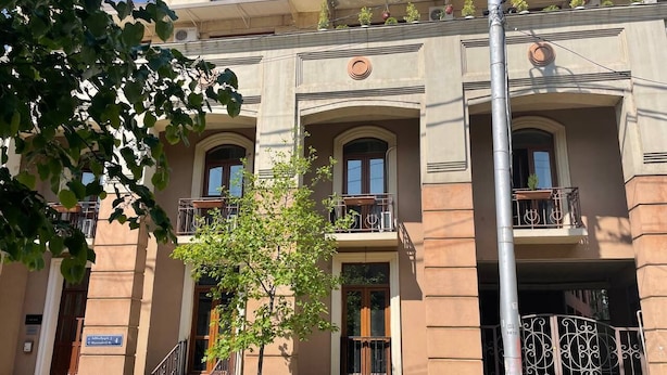 A building with a classic architectural style, featuring arched windows and balconies. - Siqvaruli (Tbilisi)