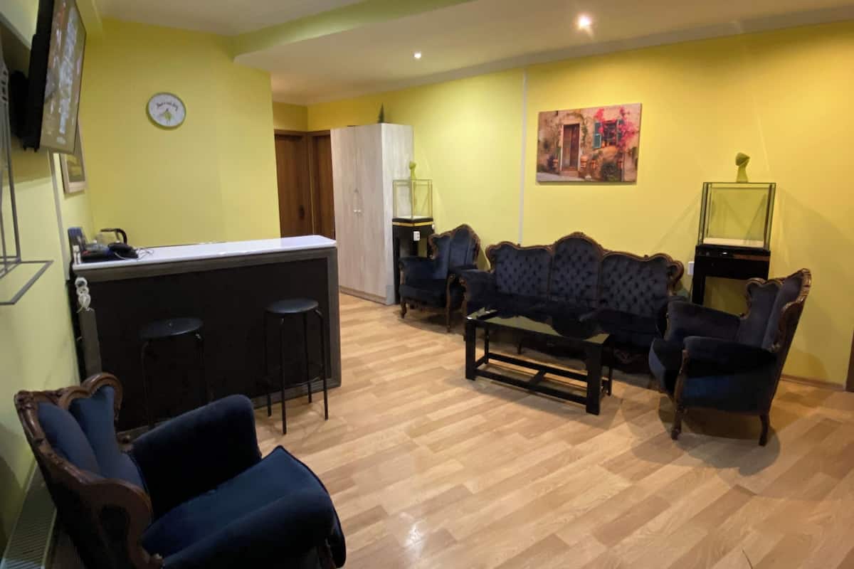 A living room with a sofa set, a coffee table, and a dining area with a bar.