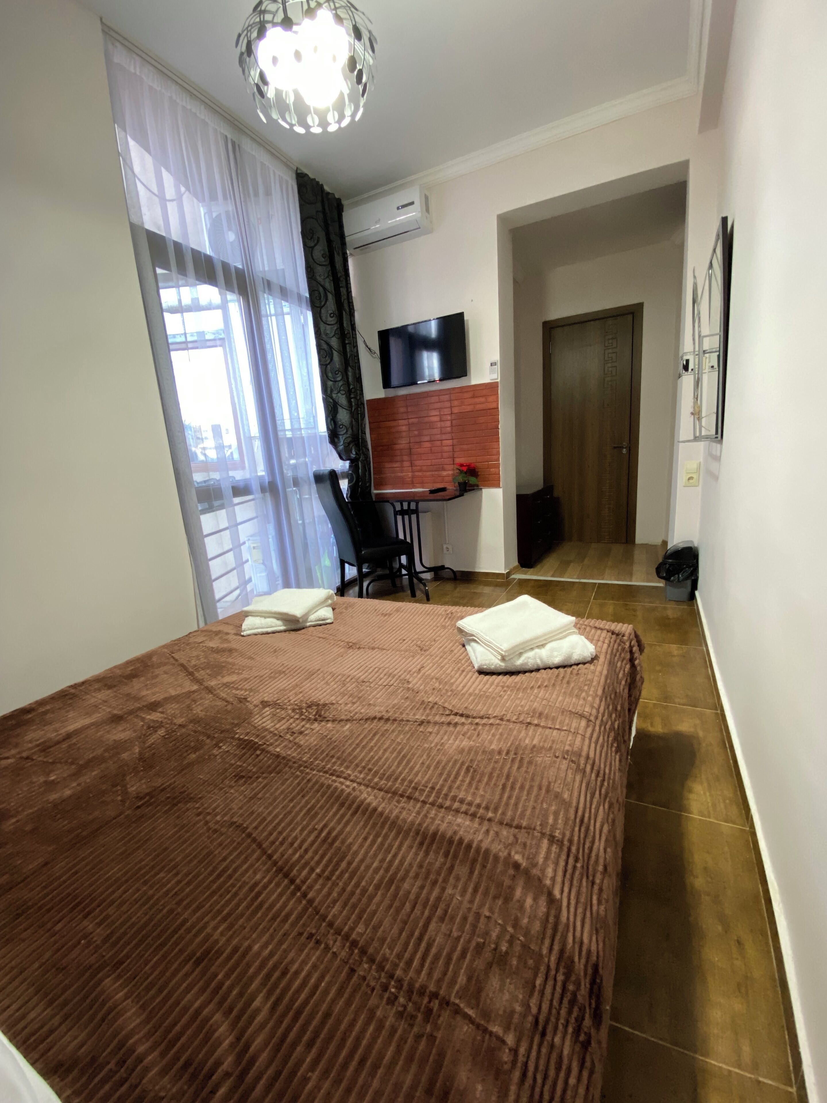 Une chambre d’hôtel équipée d’un lit, d’un bureau, d’une télévision et d’un appareil de climatisation.