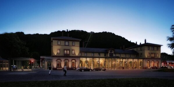 A large, multi-story building with a prominent entrance and a covered area in front. - Königsgleis-Apartments (Bad Wildbad)
