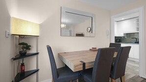 A dining area with a wooden table, four chairs, a lamp, and a potted plant. - Modern 1 Bedroom Apt in Streatham with Parking (London)