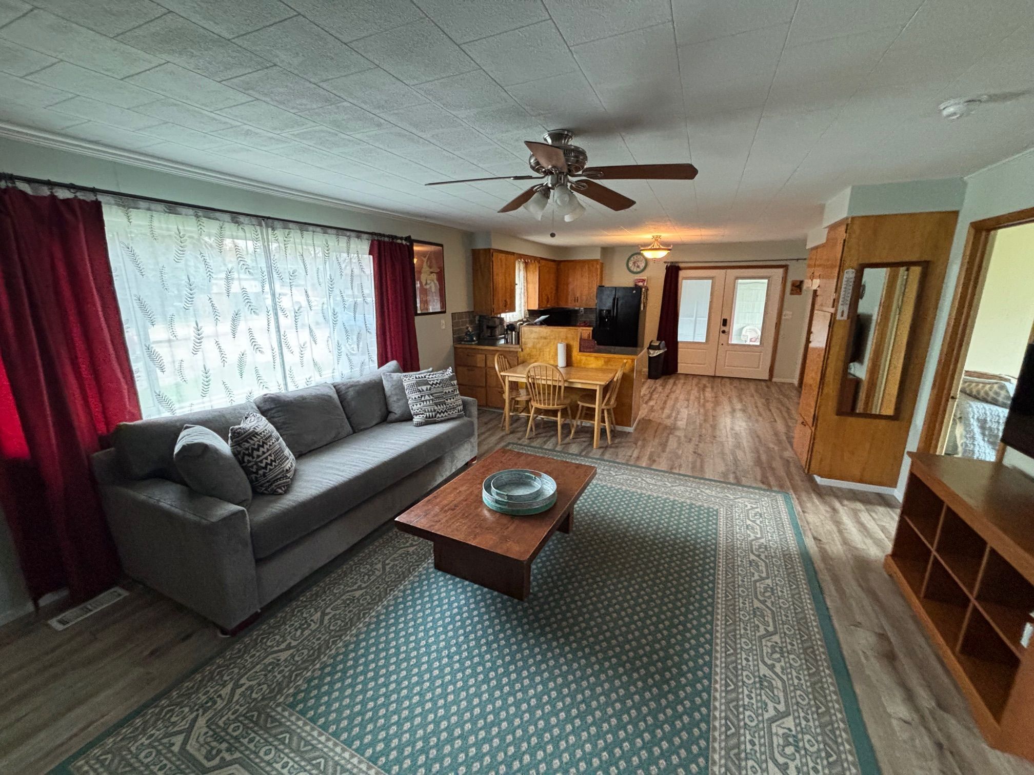 A living room with a sofa, coffee table, and patterned rug.