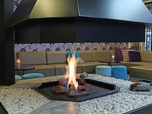 A modern outdoor seating area with a fire feature, a sofa, and a patterned wall in the background. - Make Your Trip More Enjoyable! Near Henriette Polak Museum and Stedelijk Museum (Zutphen)
