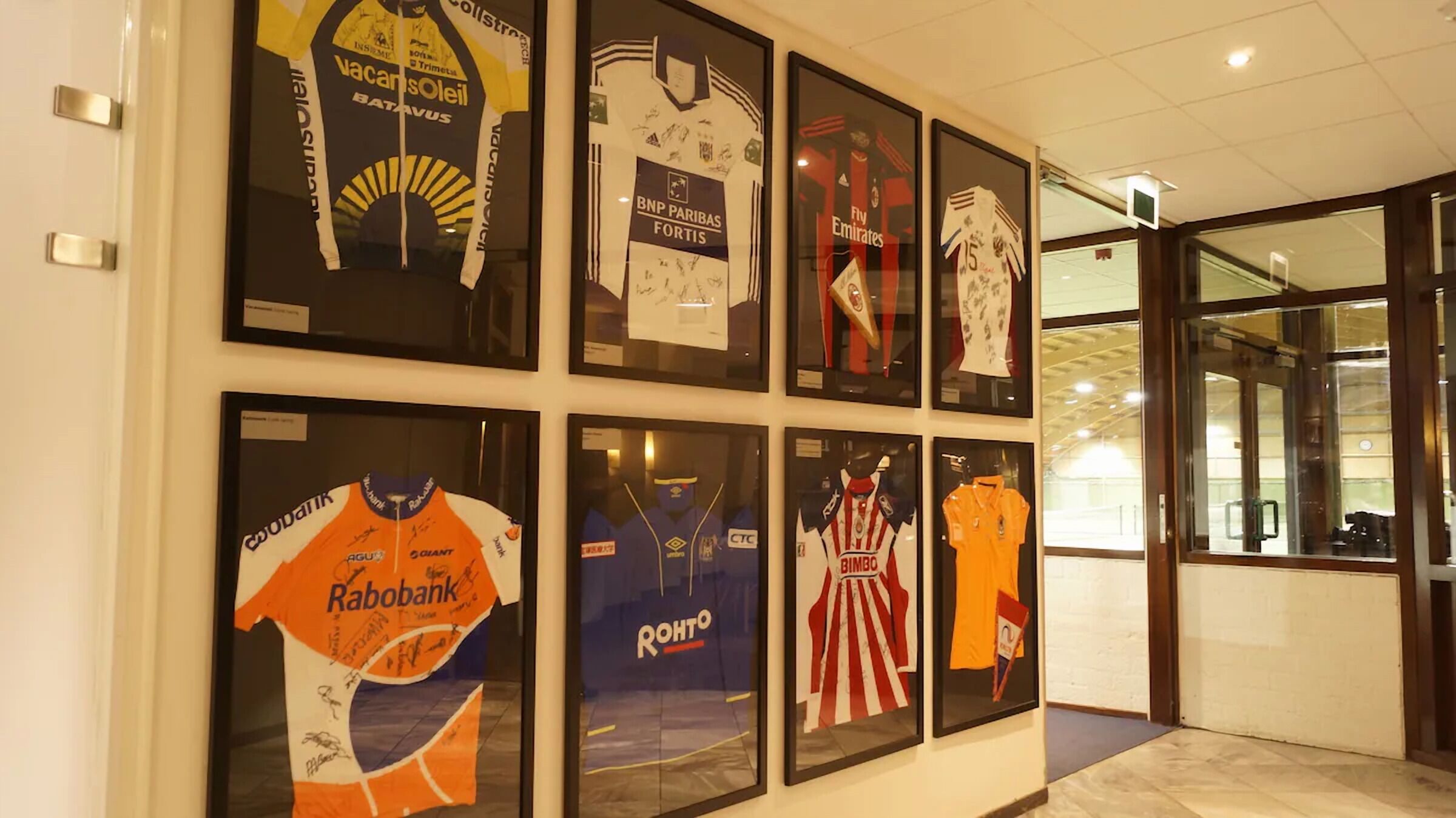 A wall with framed sports jerseys.