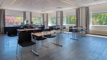 Een vergaderzaal met een lange tafel, stoelen en grote ramen.
