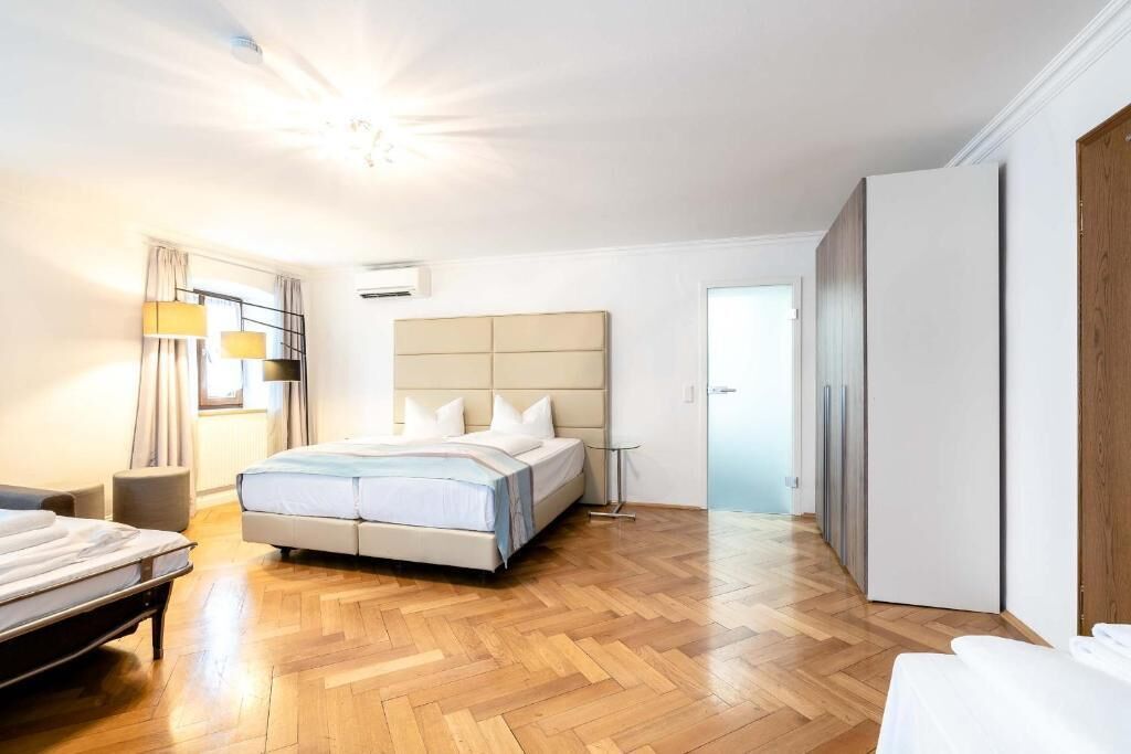 Une chambre à coucher avec un lit, une table de chevet, une lampe et une armoire.