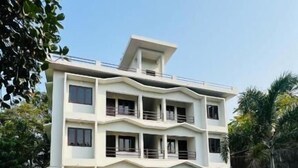 A multi-story building with a flat roof, large windows, and a paved entrance area. - Easy Nest Residency (Kannur)