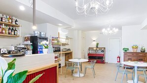 A modern cafe with a bar area, seating, and a display case.