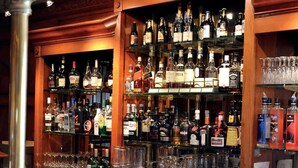 Un espace bar avec des étagères remplies de différentes bouteilles d’alcool et de verres.