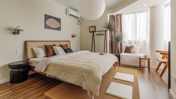 A modern bedroom with a large bed, bedside tables, a hanging light fixture, a potted plant, and a view of the outdoors. - 5 mins walk to Jing'an temple, 4br, 2bth, Family friendly! (Shang Hai Shi)
