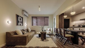 A modern living room with a sofa, coffee table, and dining area with chairs. - 5 mins walk to Jing'an temple, 4br, 2bth, Family friendly! (Shang Hai Shi)