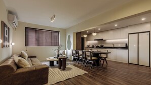 A modern living room with a sofa, dining area, and kitchen. - 5 mins walk to Jing'an temple, 4br, 2bth, Family friendly! (Shang Hai Shi)