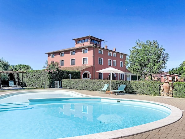 Une grande piscine avec un bâtiment rouge en arrière-plan.