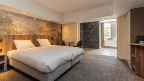 A modern bedroom with a large bed, a wooden headboard, a small table, and a chair. - Your Relaxing Base for Outdoor and City Adventures! Indoor Pool, Onsite Dining! (Berg en Dal)
