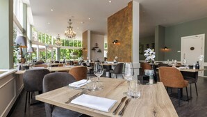 A spacious restaurant with multiple tables, chairs, and a chandelier. - Relax and Recharge! Indoor Pool and Parking, Just Minutes from Grote Markt! (Berg en Dal)