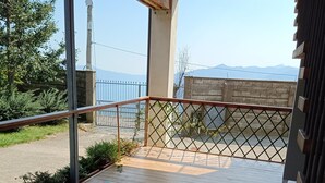A wooden deck with a star-patterned floor, a metal railing, and a view of mountains in the distance. - WEEKEND HEALTH WELLNESS REGENERATE (Bossico)