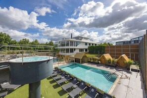 A rooftop pool with lounge chairs, a hot tub, and a building with a balcony. - Everything You Need For The Perfect Vacation! Pools, Wellness Center! (Mill)